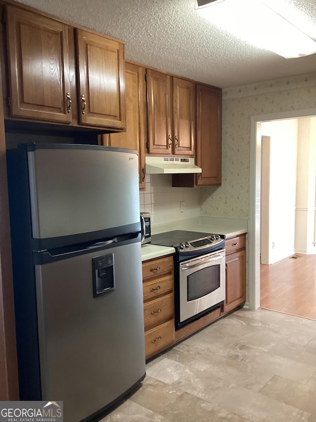 kitchen featuring a textured ceiling and stainless steel appliances