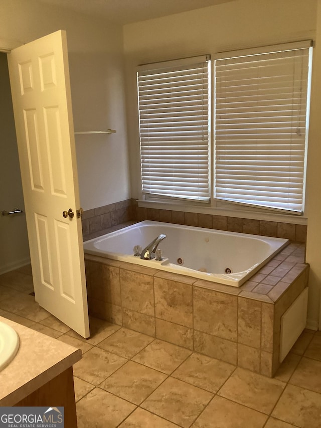 bathroom featuring tiled bath, tile patterned floors, plenty of natural light, and vanity