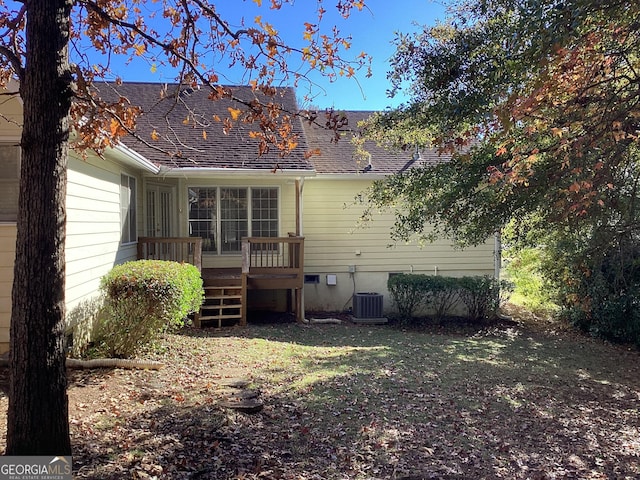 back of property with central AC unit and a deck