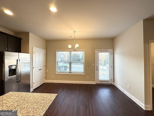 kitchen featuring stainless steel fridge, a healthy amount of sunlight, dark wood-type flooring, and hanging light fixtures