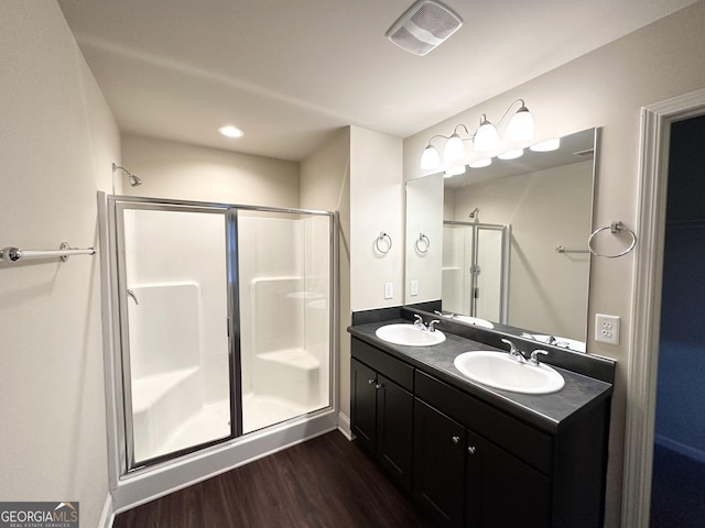 bathroom featuring vanity, hardwood / wood-style flooring, and a shower with shower door