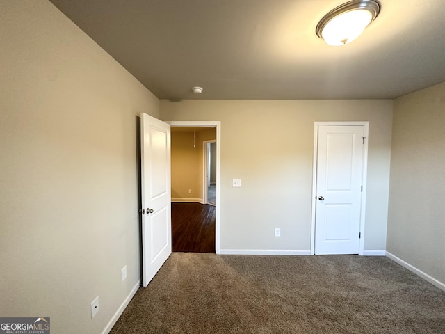 unfurnished bedroom featuring dark carpet