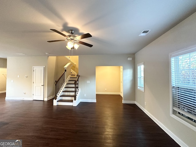 unfurnished living room with ceiling fan and dark wood-type flooring