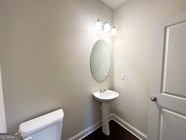 bathroom featuring hardwood / wood-style flooring and toilet