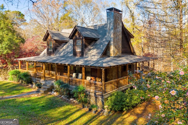 back of property featuring a lawn and covered porch