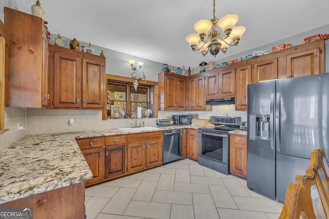 kitchen featuring pendant lighting, sink, light stone countertops, a notable chandelier, and stainless steel appliances