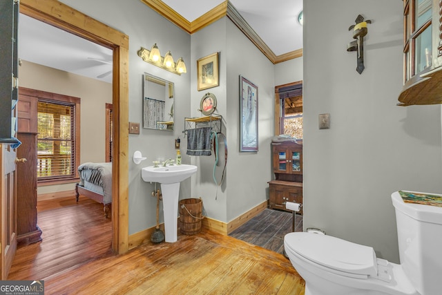 bathroom featuring hardwood / wood-style flooring, toilet, ornamental molding, and sink