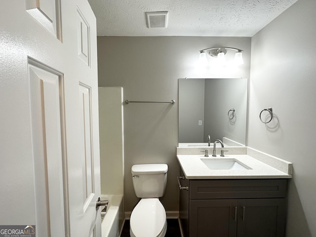 bathroom with vanity, a textured ceiling, and toilet