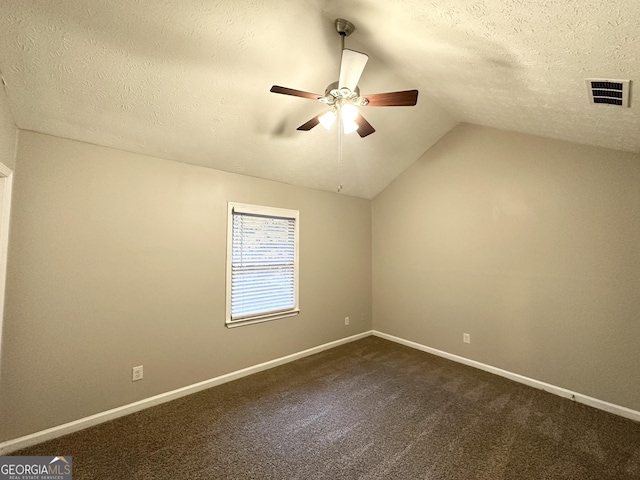 carpeted empty room featuring a textured ceiling, ceiling fan, and vaulted ceiling