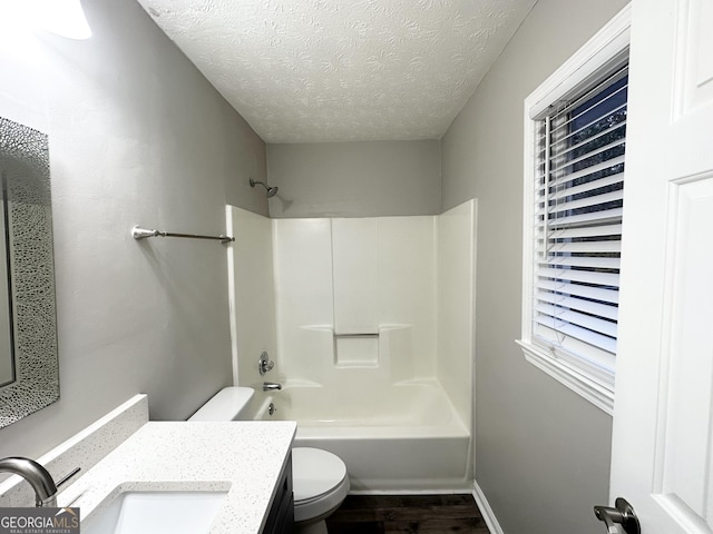 full bathroom featuring vanity, shower / bathing tub combination, a textured ceiling, and toilet