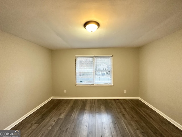 spare room with dark wood-type flooring