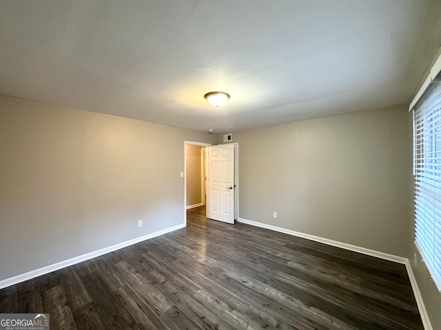 unfurnished room with dark hardwood / wood-style floors and a healthy amount of sunlight