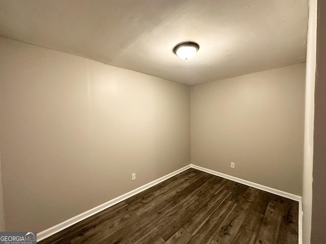 spare room with dark wood-type flooring