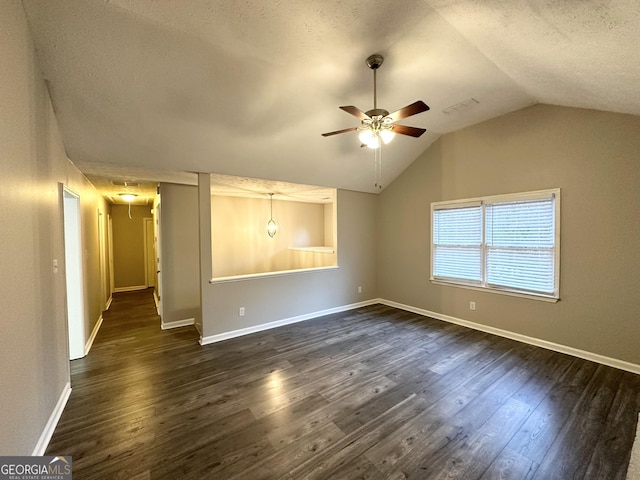 empty room featuring a textured ceiling, ceiling fan, dark wood-type flooring, and lofted ceiling