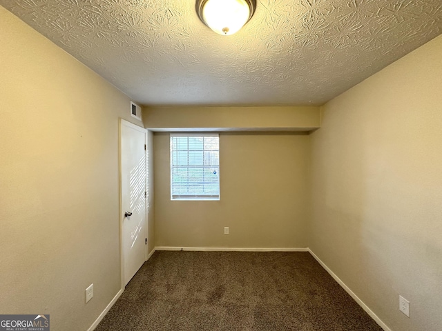 unfurnished bedroom with dark colored carpet and a textured ceiling