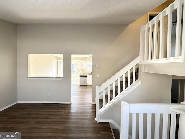 staircase featuring wood-type flooring and a textured ceiling