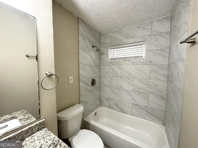 full bathroom with vanity, a textured ceiling, toilet, and tiled shower / bath