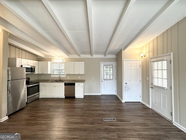 kitchen featuring white cabinetry, beamed ceiling, stainless steel appliances, and dark hardwood / wood-style floors