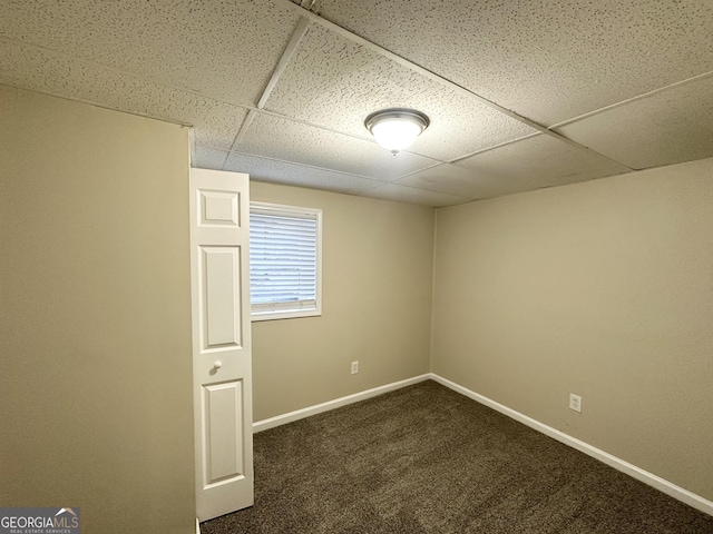 carpeted empty room with a paneled ceiling