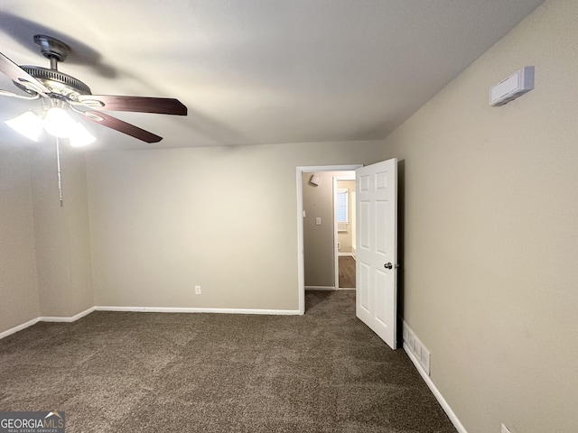 spare room featuring ceiling fan and dark carpet