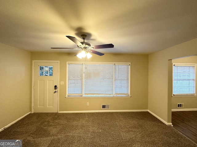 entrance foyer featuring dark carpet and ceiling fan