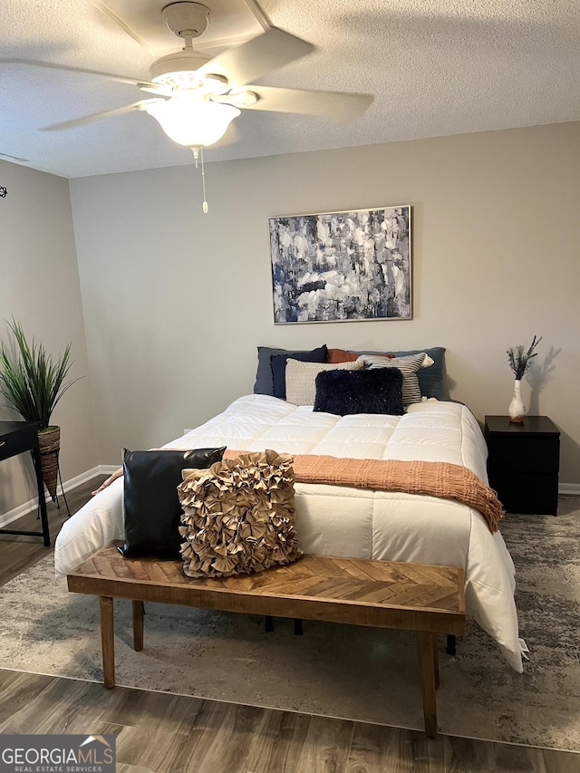 bedroom featuring hardwood / wood-style flooring, ceiling fan, and a textured ceiling