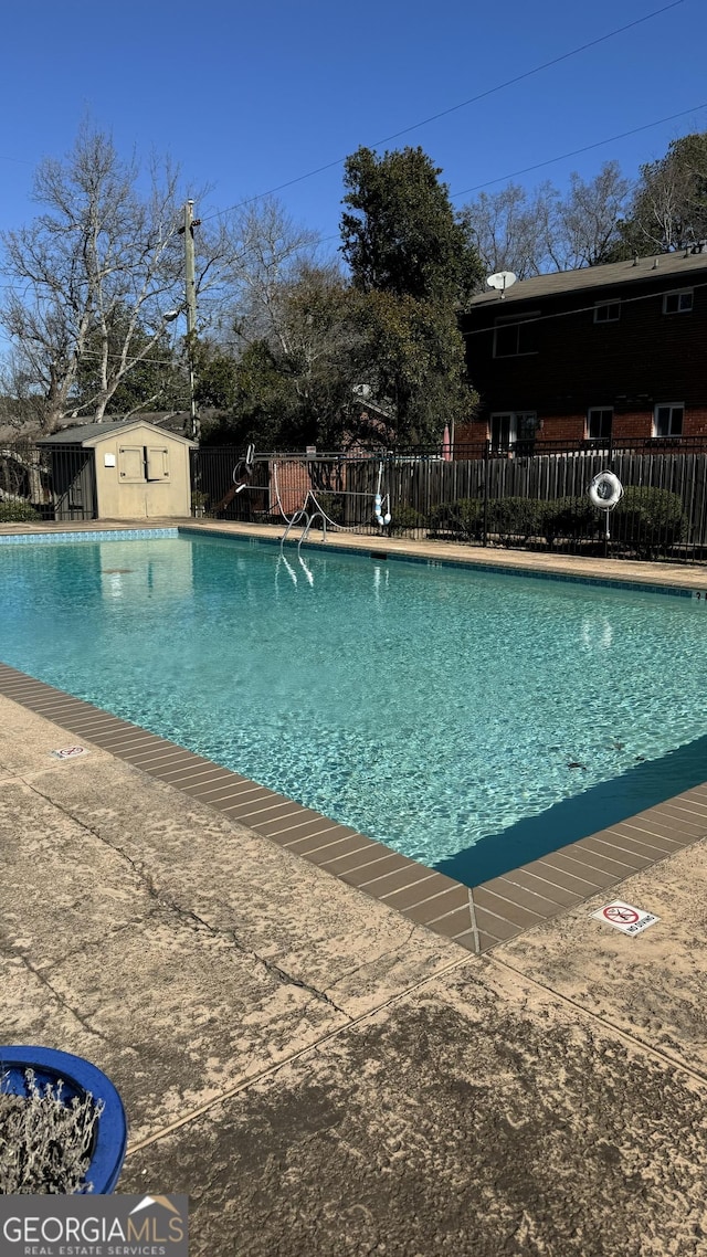 view of swimming pool featuring a storage shed