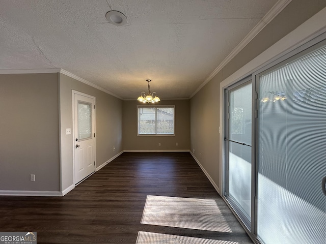 unfurnished dining area with dark hardwood / wood-style flooring, ornamental molding, a textured ceiling, and an inviting chandelier