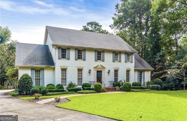 colonial house featuring a front lawn