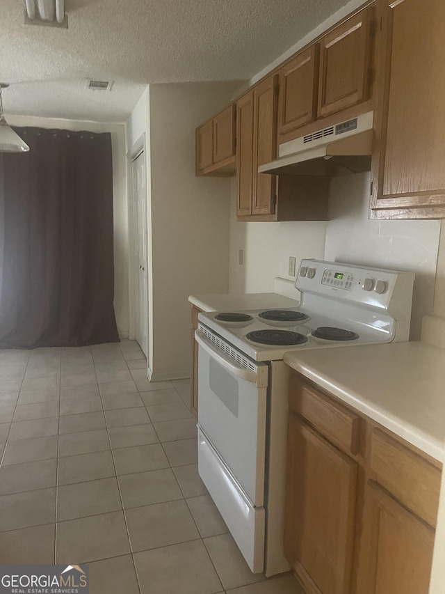 kitchen featuring electric range, light tile patterned floors, and a textured ceiling