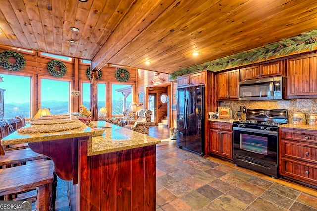 kitchen with wood ceiling, wooden walls, light stone countertops, and black appliances