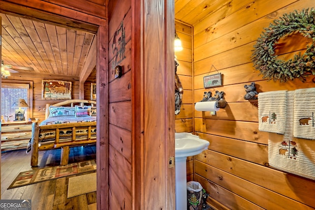 bathroom with hardwood / wood-style floors, wooden walls, ceiling fan, and wooden ceiling