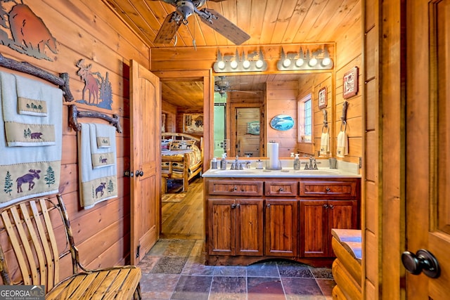 bathroom featuring vanity, wooden ceiling, ceiling fan, and wooden walls