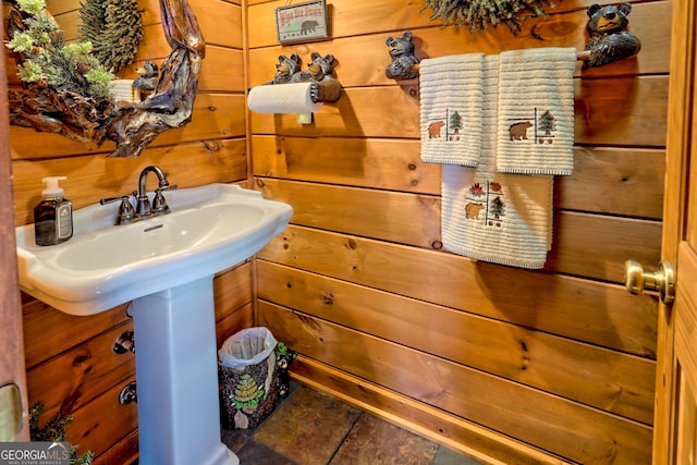 bathroom with sink and wooden walls