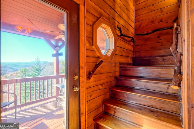 staircase featuring wooden walls