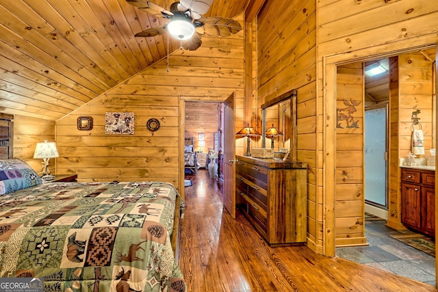 bedroom featuring wooden walls, dark hardwood / wood-style floors, and lofted ceiling