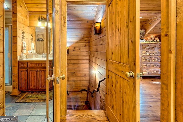 interior space featuring hardwood / wood-style flooring, wooden walls, lofted ceiling, and wood ceiling