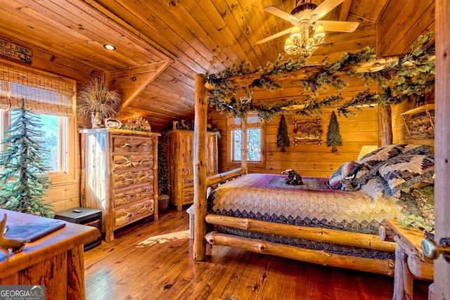 bedroom featuring wood walls, hardwood / wood-style floors, wood ceiling, and vaulted ceiling