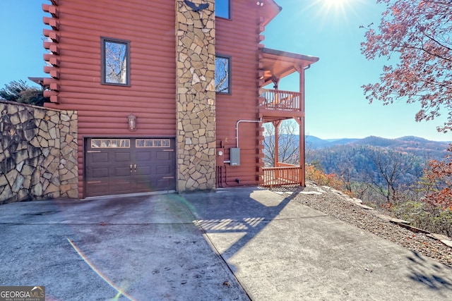 view of home's exterior featuring a mountain view, a balcony, and a garage