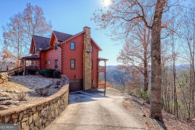 view of side of home with a mountain view and a garage