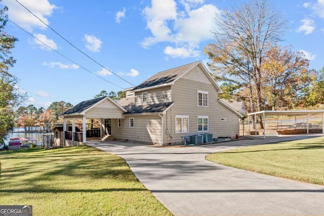 rear view of house with a lawn, central AC, and a carport