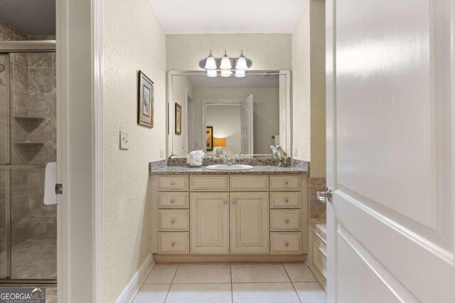 bathroom with tile patterned flooring, vanity, and an enclosed shower