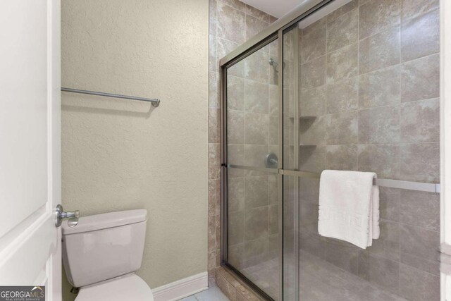 bathroom featuring toilet and walk in shower