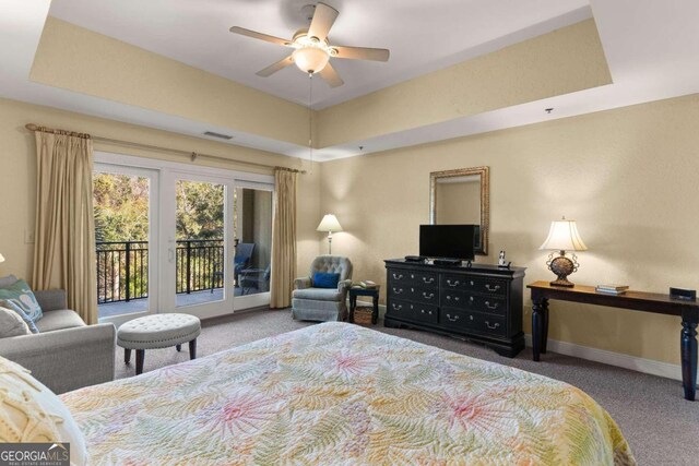 carpeted bedroom with access to outside, ceiling fan, and a tray ceiling