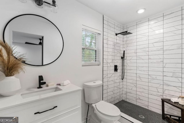 bathroom featuring tiled shower, vanity, and toilet