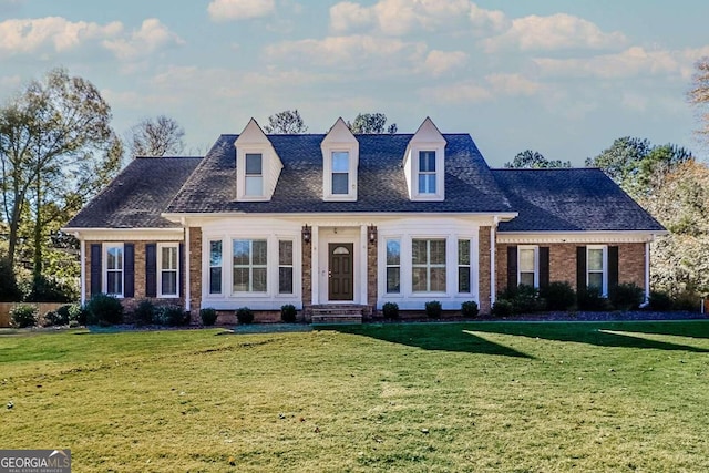 cape cod-style house with a front yard