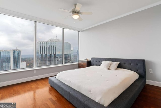 bedroom with ceiling fan, wood-type flooring, and crown molding