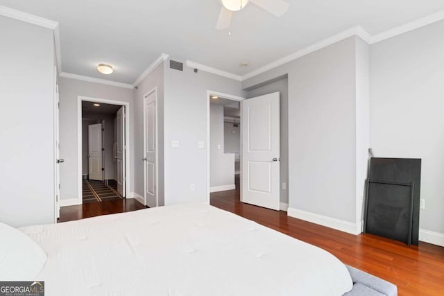 bedroom with ornamental molding, ceiling fan, and dark wood-type flooring