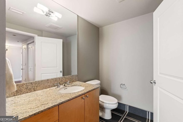 bathroom featuring tile patterned flooring, vanity, and toilet