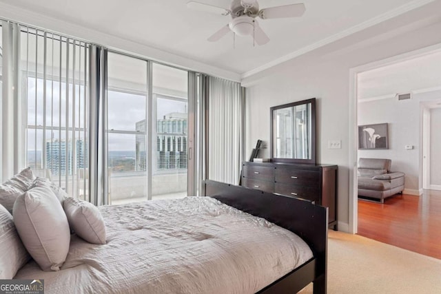 bedroom featuring access to exterior, wood-type flooring, ceiling fan, and ornamental molding